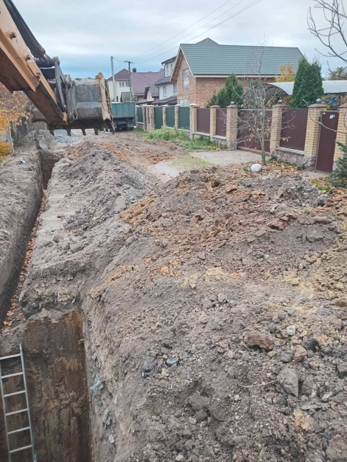 Копання траншеї під комунікації екскаватором у Київській області